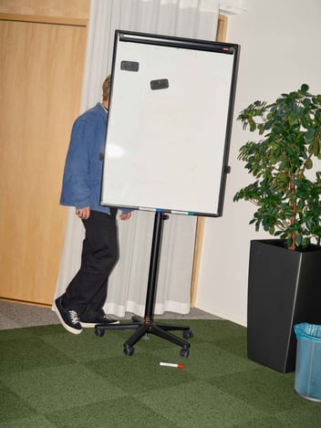 a person walking behind a whiteboard