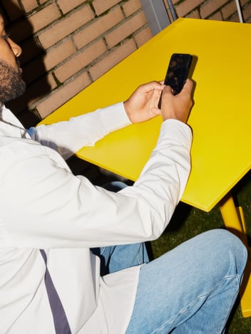 a person holding a phone on a yellow table