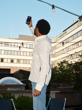 person holding an iphone towards the sky