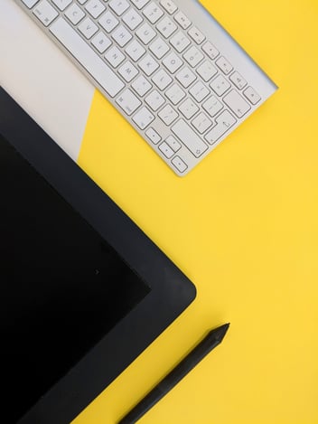 Tablet and keyboard on a yellow table 